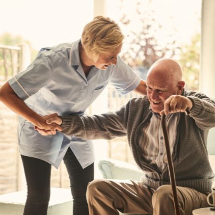 An old white man receiving supported living services from a nurse provided by Biston Healthcare